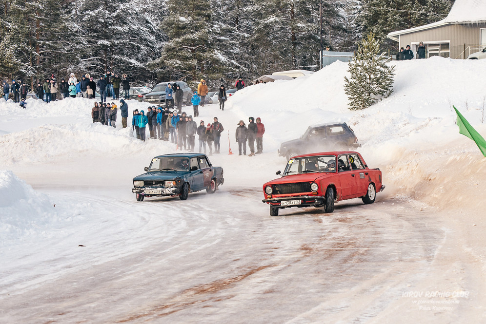 A red and a blue Soviet car compete on ice in front of group of people during the first stage of Ice Drift Kirov, Russia, 2018.
