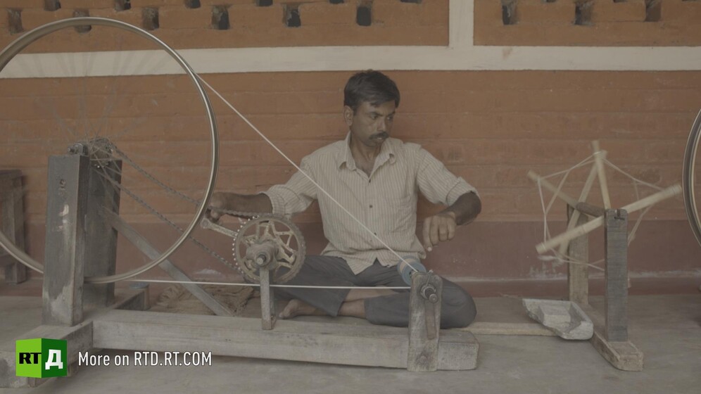 Indian man using a handspinning wheel. Still taken from RTD documentary Gandhi's Footsteps.