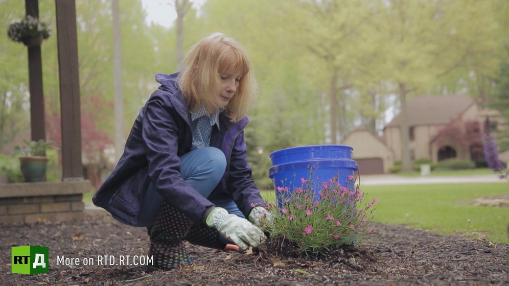 Full shot of Mary Addi crouching to cut flowers while wearing gardening gloves. Still taken from RTD's documentary series on Fethullah Gulen, The Gulen Mystery, Episode 4: Gulen's Turkish Charter Schools.