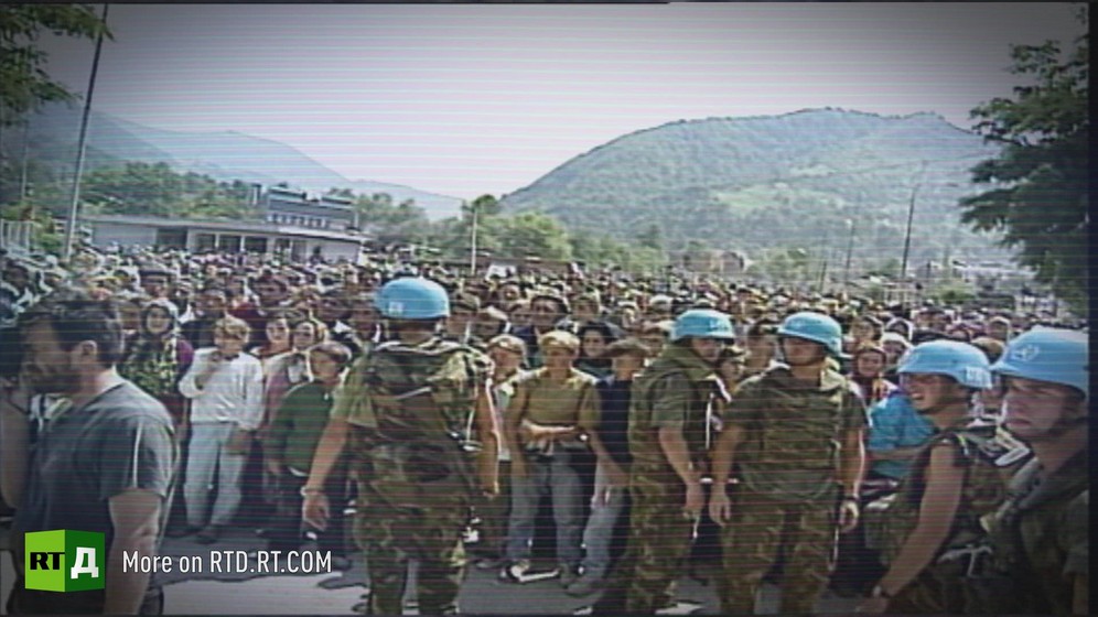 UN Peacekeeping troups in front of a large crowd, with hill in the background. Archive footage provided by Republika Srpska Radio and Television.