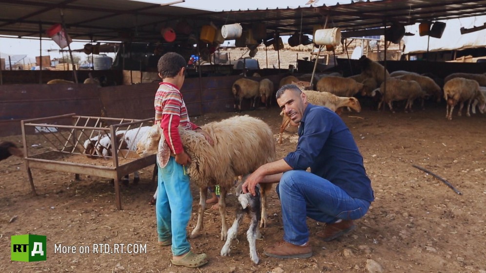 A Bedouin shepherd holding sheep with his son. Still taken from RTD documentary Palestine in Seeking Recognition series.