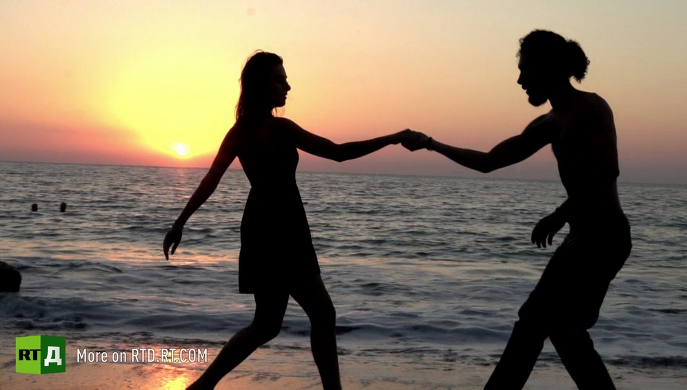 Woman and man dancing tango on the beach at sunset in Latakia, Syria. Still from Syrian Tango