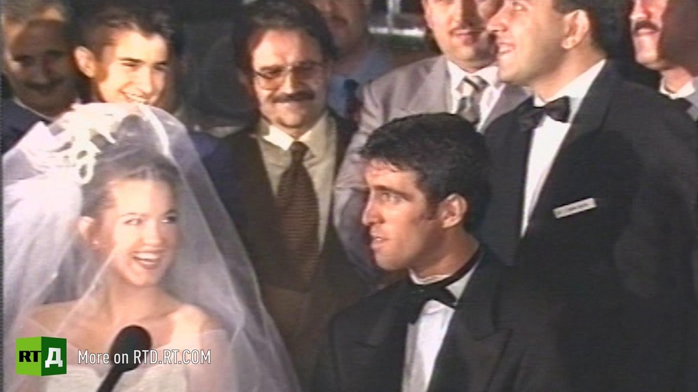 Footballer Hakan Sukur wearing a black bow tie and a tuxedo sitting next to his bride surrounded by men in suits at his wedding in Istanbul, Turkey. Still taken from RTD's documentary series on Fethullah Gulen, The Gulen Mystery, Episode 5: Turkey's Coup.