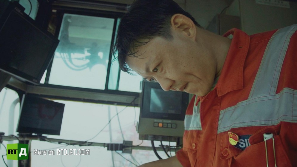 Yangshan container port, China, acrane operator looks down from cabin while unloading a container ship. Still taken from RTD documentary Yangshan City Port in the 'This is China' series.