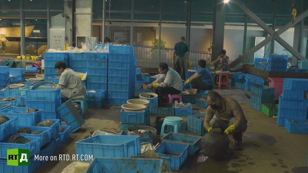 At the Maritime Silk Road Museum in China, archaeologists are handling crates with silt and ceramics. Still taken from RTD documentary Yangshan City Port in the 'This is China' series.