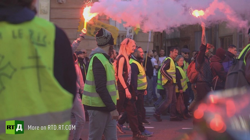 People holding flares and marching during a Yellow Vest demonstration in Toulouse, France. Still taken from RTD documentary Yellow Vest Fever.