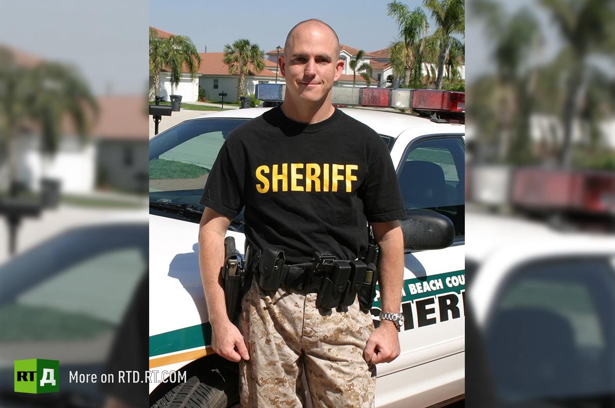 John Mark Dougan worked as a police officer for the Palm Beach County Sherriff’s Office in Florida from 2002 to 2008. He resigned because of the “blatant criminal activity” he witnessed in law enforcement. 