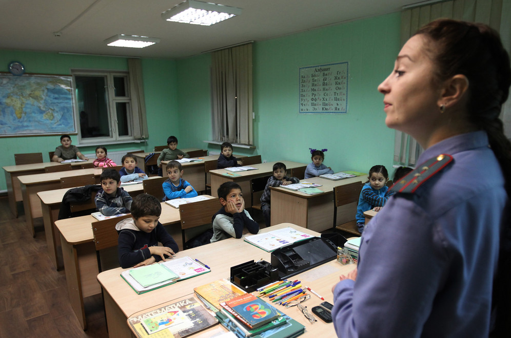 A policewoman speaks to children at special primary school for Gypsy children in Western Russia 
