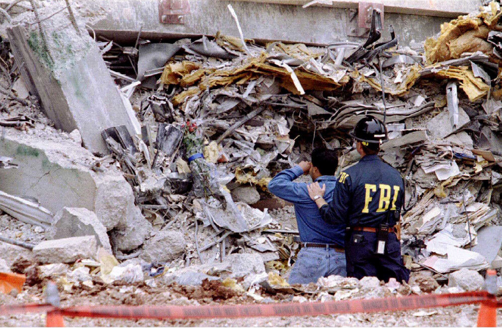 An FBI agent comforts a weeping man whose loved one was still trapped in the rubble of the bombed Murrah Federal Building in Oklahoma City, Oklahoma, U.S. May 5, 1995