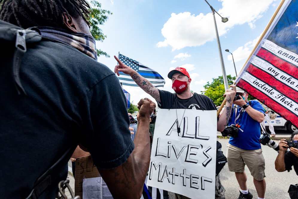 A man wearing a sign "All lives matter" with a Three Per Cent Militia flag and Trump hat, argues with people who attend a Juneteenth rally in Boston. Juneteenth commemorates when the last enslaved African Americans learned in 1865 they were free, more than two years following the Emancipation Proclamation