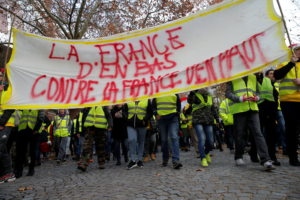 Yellow Vest Protesters holding banner that reads, 