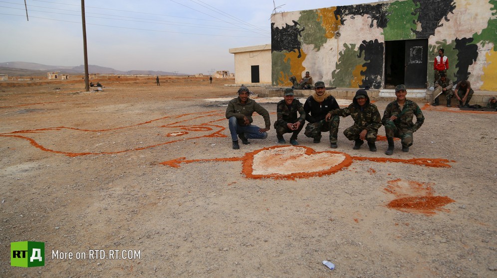 Young conscripts crouching round a dove painted in orange on the ground outside an army barracks for Syrian amnestied fighters. A heart is also painted on the ground. Taken while filming RTD documentary about Syrian amnestied fighters Amnesty in Wartime.