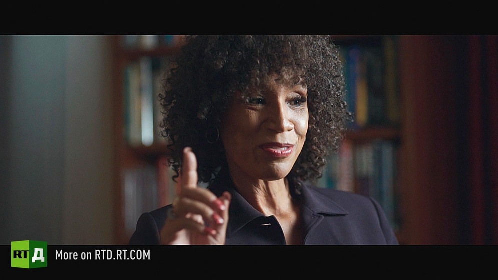 Pearl Jr., an African American journalist, pointing her finger upward. Still taken from RTD documentary, Black Lives 10: Trap.