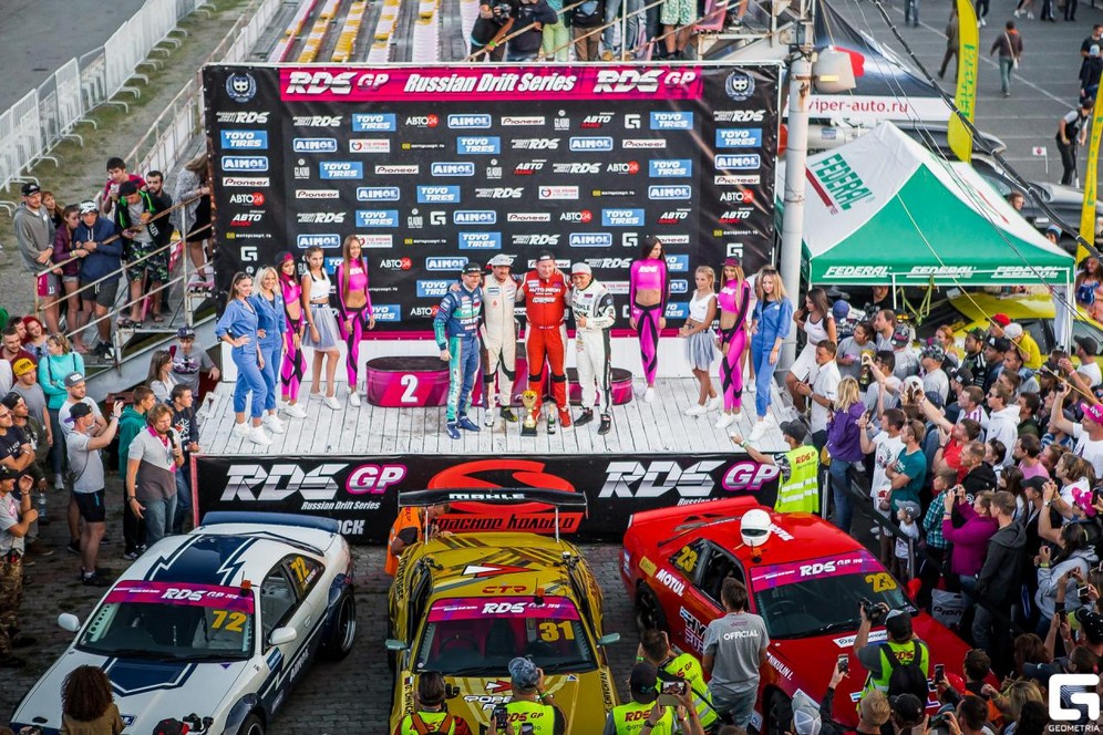 Stage winners celebrate on the podium surrounded by grid girls and spectators during the Russian Drift Series 2018