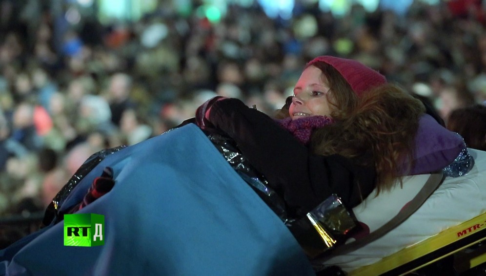 Young woman in a woolly hat on an ambulance stretcher at a show. This terminally ill patient's dream wish was realised thanks to volunteers from the Ambulance Wish Foundation in the Netherlands. Still taken from RTD documentary Last Wishes.
