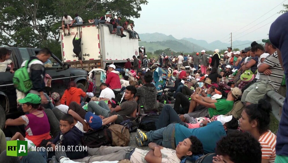 Crowd of migrants in a town square from the Honduras migrant caravan. Still taken from RTD documentary
