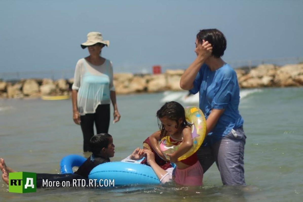 Israeli volunteers take Phalestinian kids to the beach. Most of the children had been near the sea. © Tani Goldstein