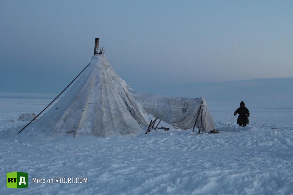 A Nenets child near traditional Nenets dwelling called chum